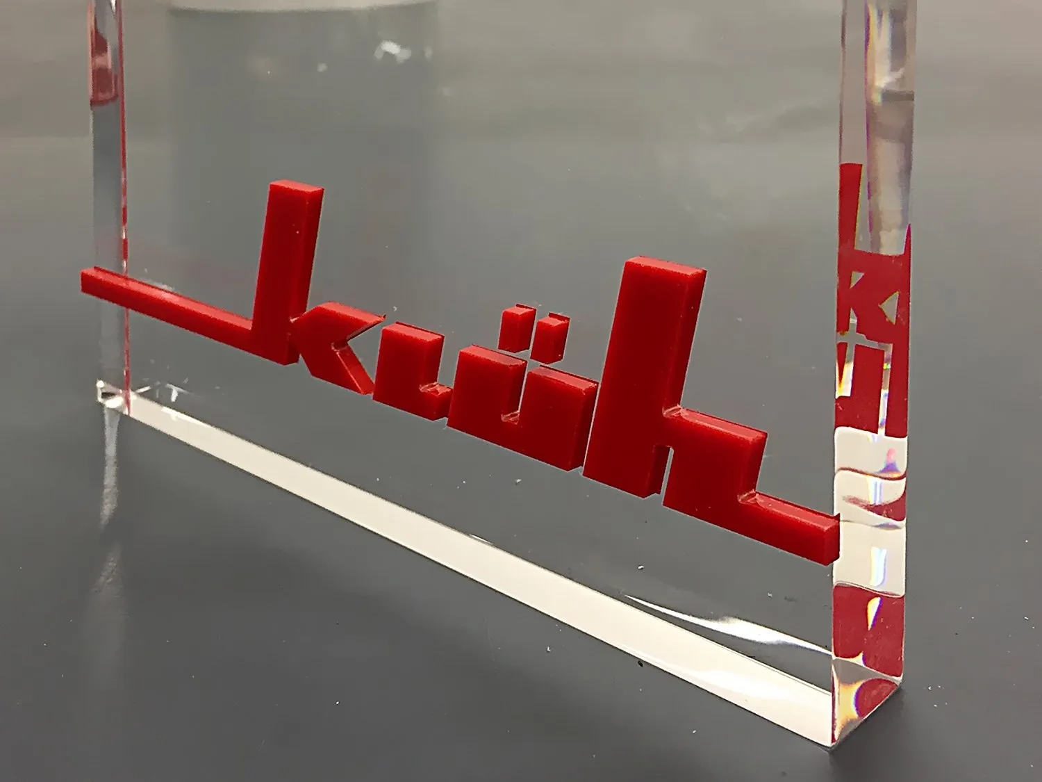 Roter 3D-Schriftzug hinter klarem Acrylglas