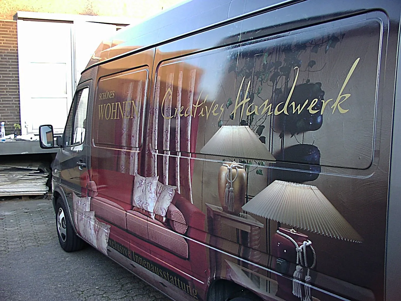 Fahrzeugbeschriftung auf einem dunklen Transporter