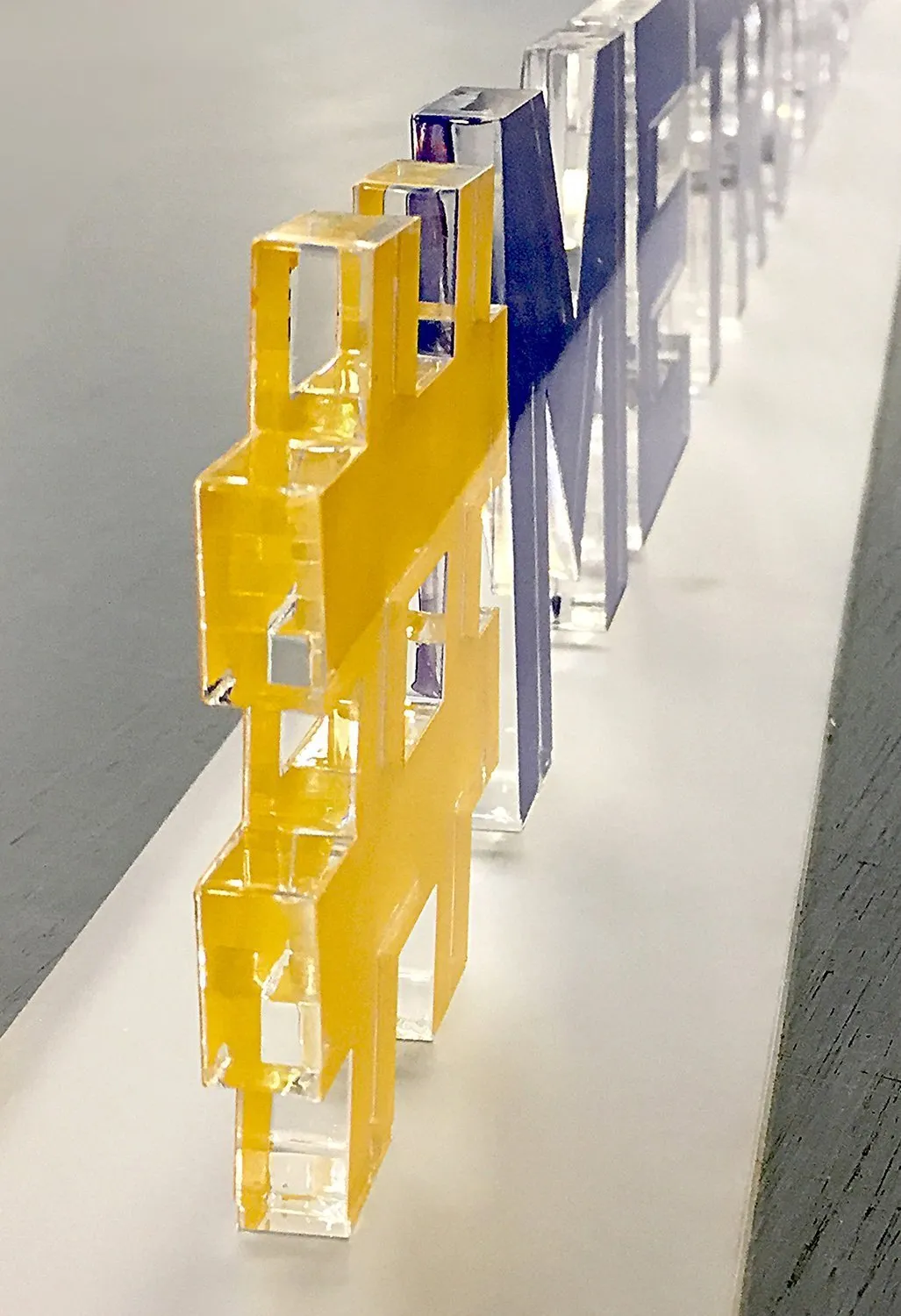 Lasergeschnittene Buchstaben aus gelbem Acrylglas